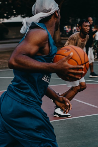 穿着蓝色篮球制服的男子，在球场上拿球